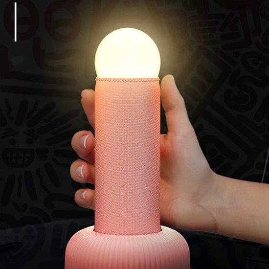 Roze tafellamp met een bolvormige lampenkap. De lamp heeft een stoffen textuur.