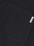 Detail van een donkerblauwe joggingbroek met opgestikte zak en logo.