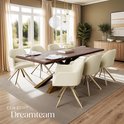 Een crèmekleurige fluwelen eettafelstoel met gouden poten in een stijlvolle eetkamer met een houten tafel.