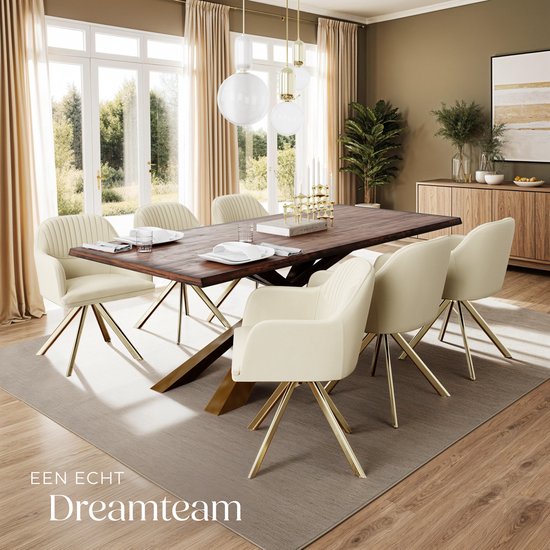 Een crèmekleurige fluwelen eettafelstoel met gouden poten in een stijlvolle eetkamer met een houten tafel.