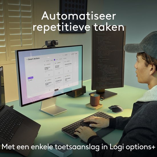 Personne travaillant à un bureau avec un clavier Logitech MX Keys S gris et une souris noire.