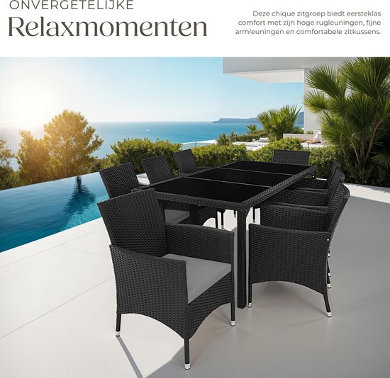 Zwarte wicker tuinset met tafel en 8 stoelen met grijze kussens, bij een zwembad aan zee.