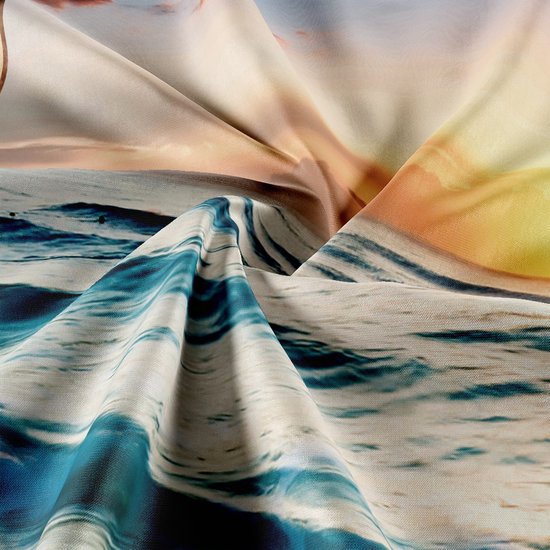 Gros plan de vagues et de coucher de soleil sur une tapisserie en tissu.