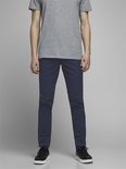 Model in een grijs T-shirt en een marineblauwe chino. De voorkant van de broek is zichtbaar.