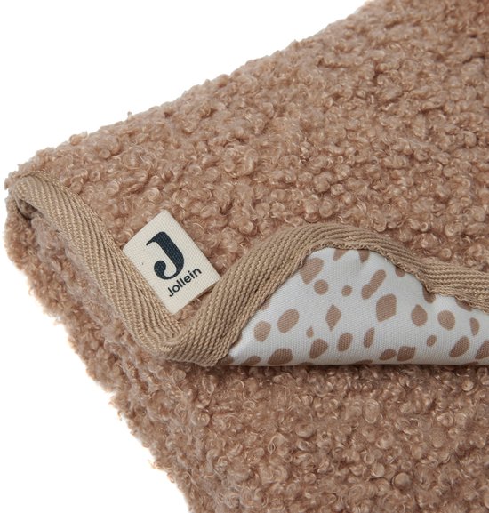 Detail van bruin, teddy-achtig verschoningsmatje met beige rand en Jollein-label. Beige stippen zichtbaar aan binnenkant.