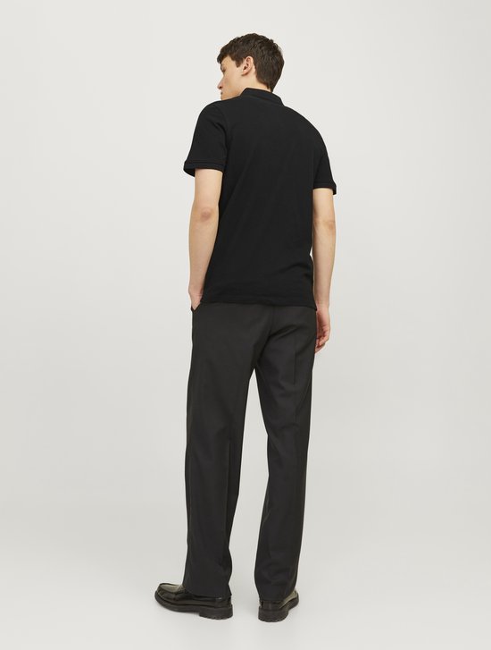 Man draagt een zwarte polo en een zwarte pantalon, van achteren gezien.
