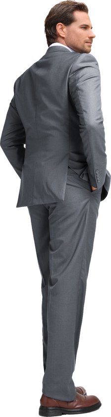 Homme en costume gris, debout dos à la caméra, mains dans les poches.