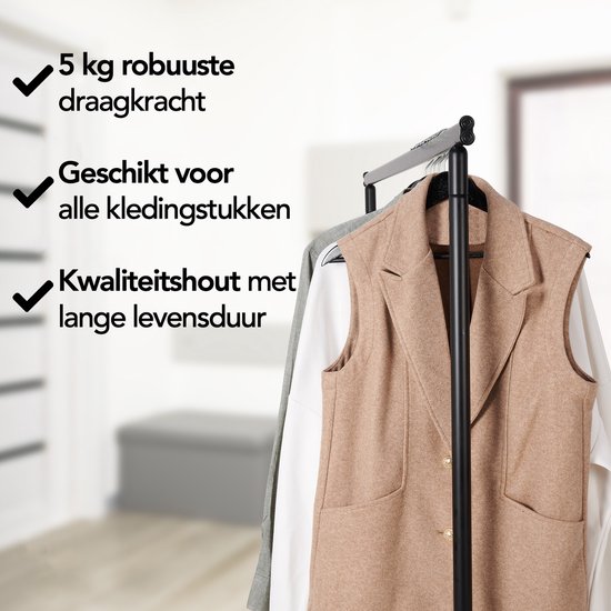 Gilet marron, blouse blanche et haut gris sur des cintres noirs sur un portant.