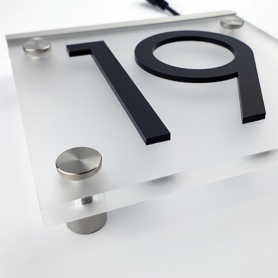Close-up van huisnummer 19 op een vierkant, matglazen bord met zilveren bevestigingen.