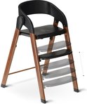 Chaise haute Deryan noire avec pieds aspect bois et repose-pieds réglables.
