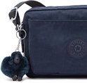 Close-up van een donkerblauwe Kipling schoudertas met een Kipling-logo en een donkerblauwe pompon-sleutelhanger.