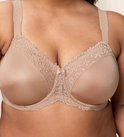 Close-up van een volle buste met een nude beha met geborduurde kantafzetting op de cups en bandjes. Klein strikje in het midden.