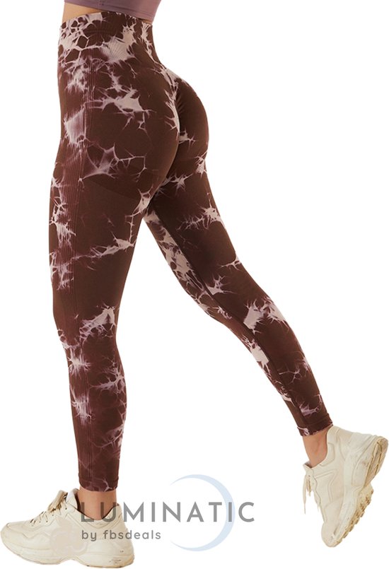 Vrouw met bruine tie-dye sportlegging, hoge taille, witte sneakers.