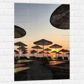 WallClassics - Muursticker - Strand met Ligbedden en Rieten Parasols - 60x90 cm Foto op Muursticker