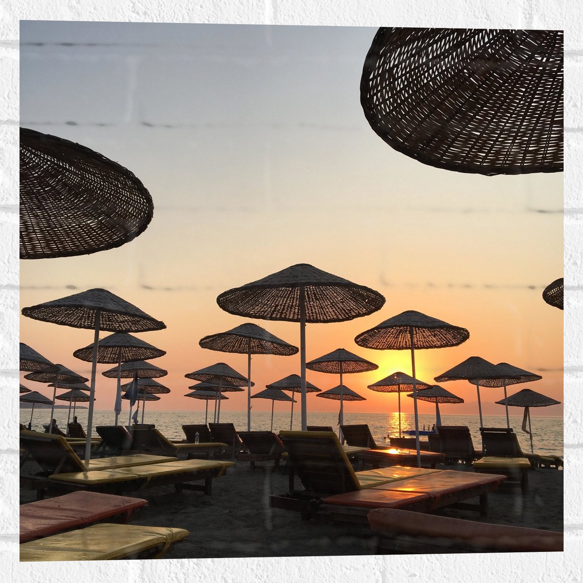 Muursticker - Strand met Ligbedden en Rieten Parasols - 50x50 cm Foto op Muursticker