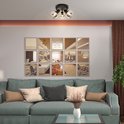 Zwarte plafondlamp met drie spots, boven een sofa in een woonkamer.