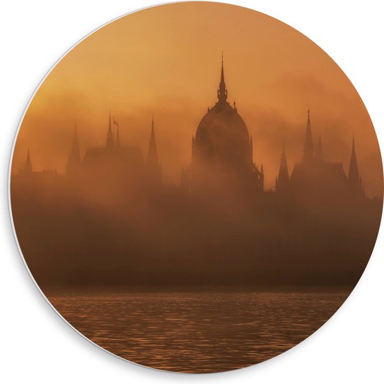 PVC Schuimplaat Muurcirkel - Foto van Hongaars Parlementsgebouw aan het Water met Mist Ervoor - 50x50 cm Foto op Muurcirkel (met ophangsysteem)