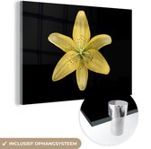 MuchoWow® Glasschilderij 60x40 cm - Schilderij acrylglas - Een gele leliebloem over zwarte achtergrond - Foto op glas - Schilderijen
