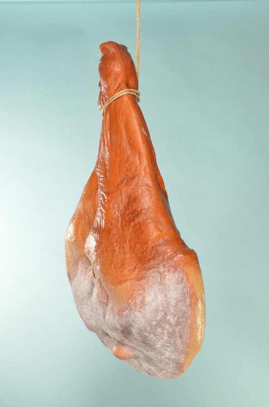 Bruin gedroogd hammetje met grijze schimmel, opgehangen met touw.