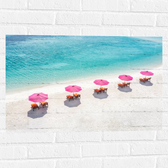 Muursticker - Ligbedden onder Roze Parasols op het Witte Strand bij Blauwe Oceaan - 75x50 cm Foto op Muursticker