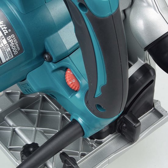 Close-up van de turquoise Makita cirkelzaag, met een rode aan/uit-knop.
