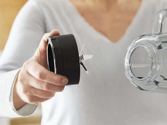 Hand houdt een zwarte mesunit van een Tefal blender vast.