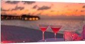 Tuinposter – Tafeltje op het Strand met Cocktails in de Avond - 200x100 cm Foto op Tuinposter (wanddecoratie voor buiten en binnen)