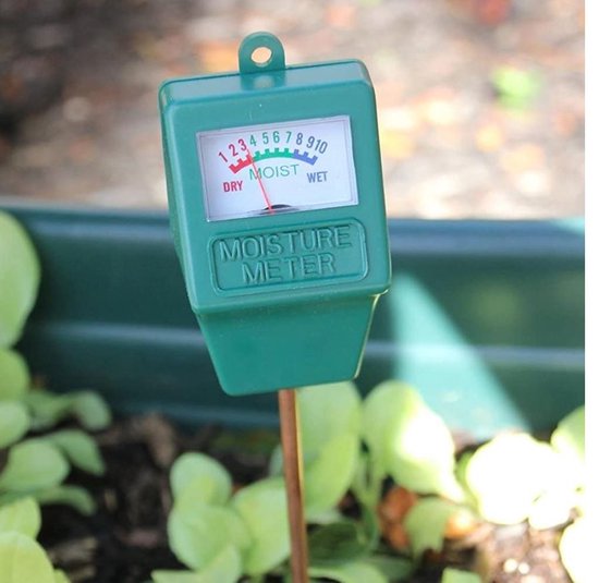 Groene vochtigheidsmeter in de aarde bij planten.