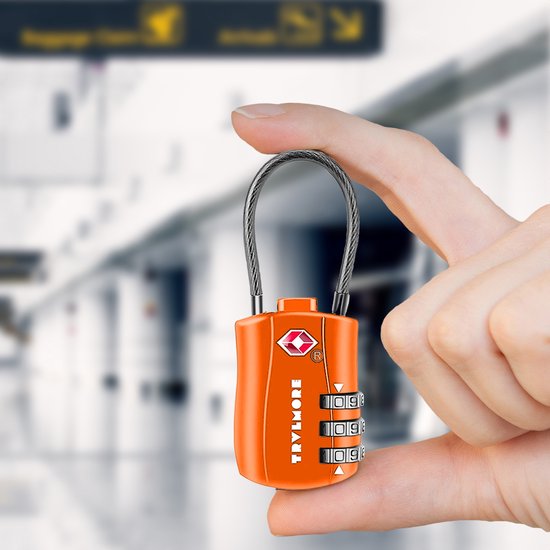 Vinger die een oranje TSA-combinatieslot vasthoudt in een luchthaventerminal.