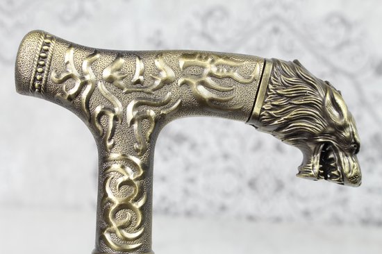 Gouden handvat van een wandelstok met een gedetailleerde wolfskop en sierlijke patronen.