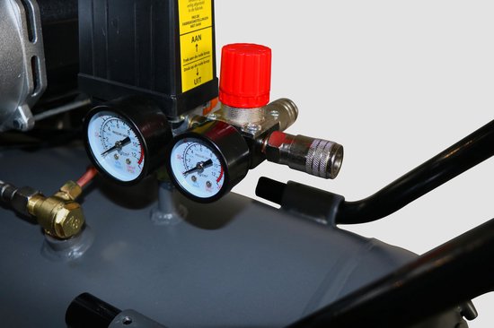 Close-up van een luchtdrukmeter met rode en witte wijzers, naast een rode draaiknop.