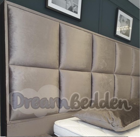 Taupe gestoffeerd hoofdbord met vierkante patronen, dichtbij gefotografeerd, met een kussen.