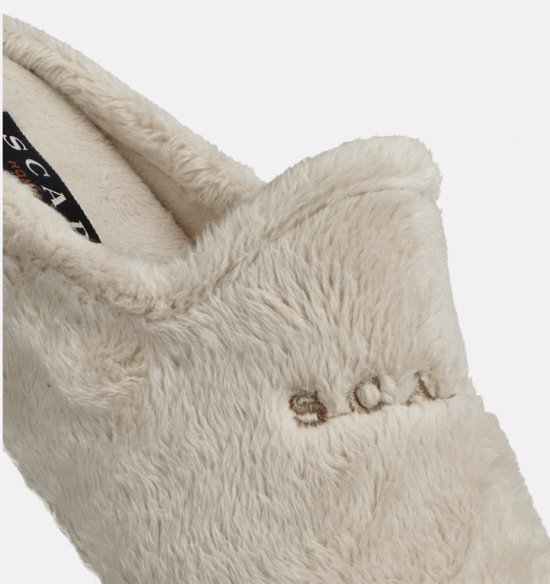 Detail van de crèmekleurige, pluizige pantoffel met het subtiel geborduurde Scapa-logo op de wreef.