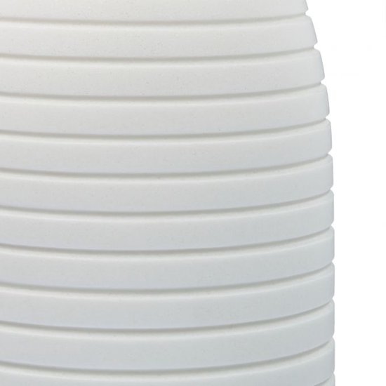 Close-up van de witte, ribbelige textuur van een zeepdispenser.