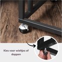 Close-up van de wieltjes en verstelbare pootjes van een zwart bijzettafeltje.