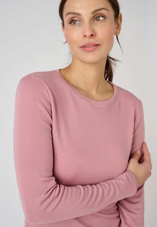 Buste van een vrouw met een roze longsleeve T-shirt, fijn geribd.