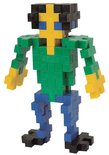 Een mensfiguur gemaakt van kleurrijke Plus-Plus bouwstenen: groen shirt, blauwe broek, gele armen en gezicht, zwarte voeten en hoofd.