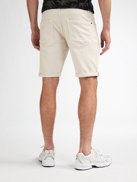 Achterkant van een beige korte broek met opgerolde zoom.