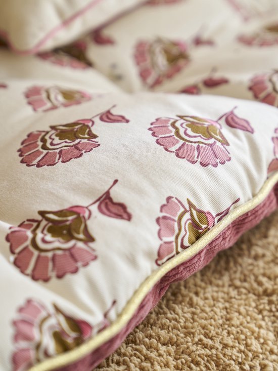 Detail van een lichtroze vloermatras met bloemenprint en een roze corduroy rand.