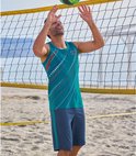 Man speelt beachvolleybal in een petrolgroen sportshirt met grafische print en een marineblauwe short met zijkantstreep.