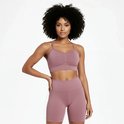 Vrouw met afro haar, van voren gezien, draagt een roze sportbeha met ruching en een roze fietsbroek.