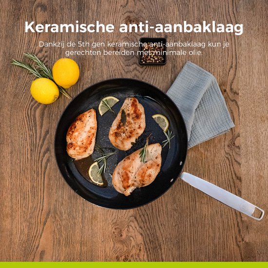 Drie stukken kipfilet worden gebakken in een koekenpan met citroenpartjes en rozemarijn.