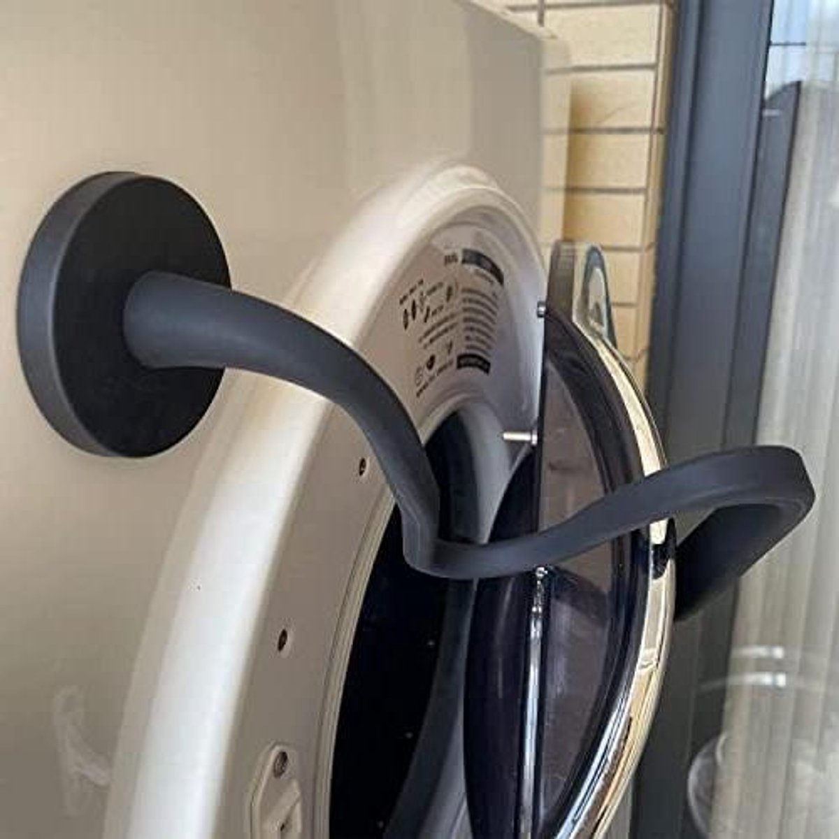 Deursteun voor wasmachine met magnetische deurhouder in zwart, universeel toepasbaar.