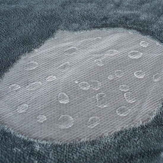 Detail van een grijze stof met een transparant, waterdicht inzetstuk bezaaid met waterdruppels.