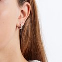 Model met zilveren oorring met witte steentjes.