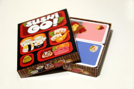 Doos van het kaartspel Sushi Go! met een rode voorkant met afbeeldingen van sushi en een open doos met speelkaarten.