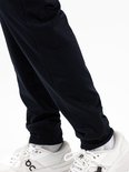 Detail van de donkerblauwe trainingsbroek met mesh inzetstukken aan de zijkanten.