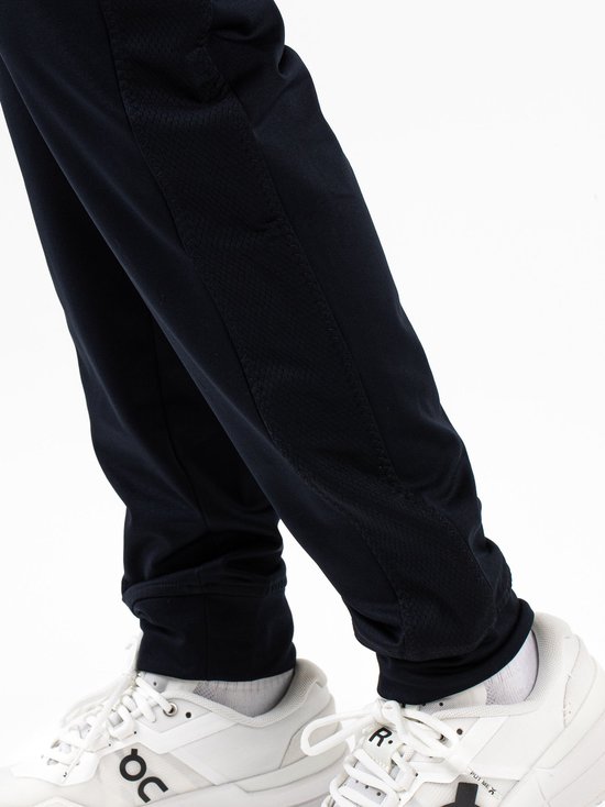 Detail van de donkerblauwe trainingsbroek met mesh inzetstukken aan de zijkanten.