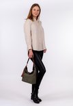 Khakigroene handtas aan een model met een beige blouse en zwarte broek.
