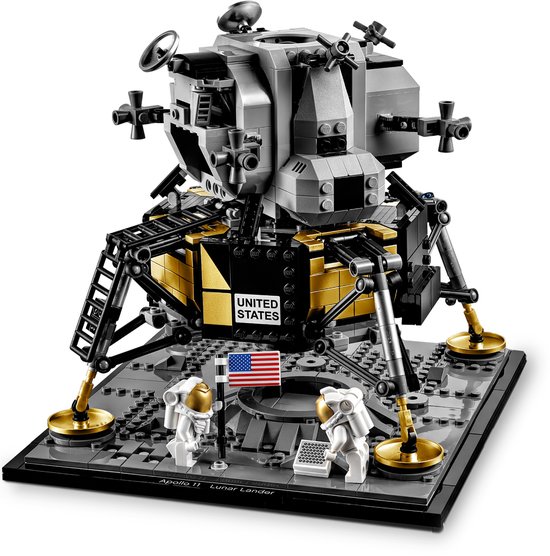 Grijze en gouden maanlander met 'United States' opdruk, twee astronauten, vlag en ladder op grijze basis.